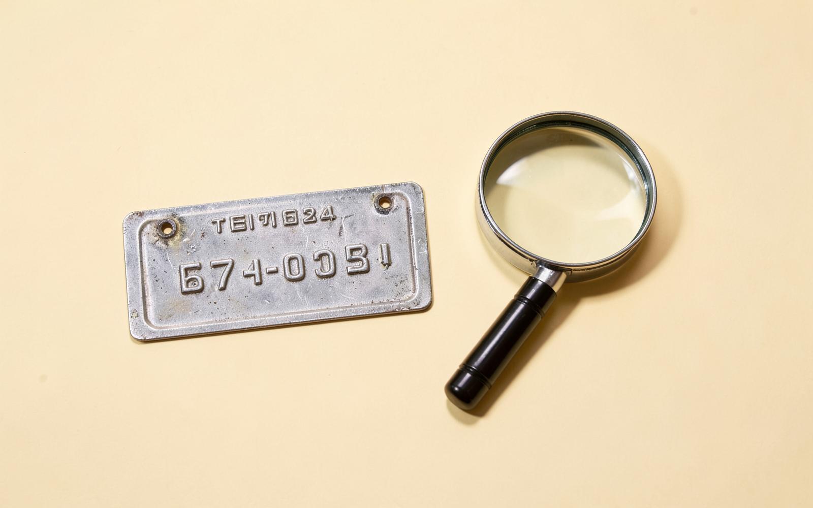 Vehicle identification plate and magnifying glass